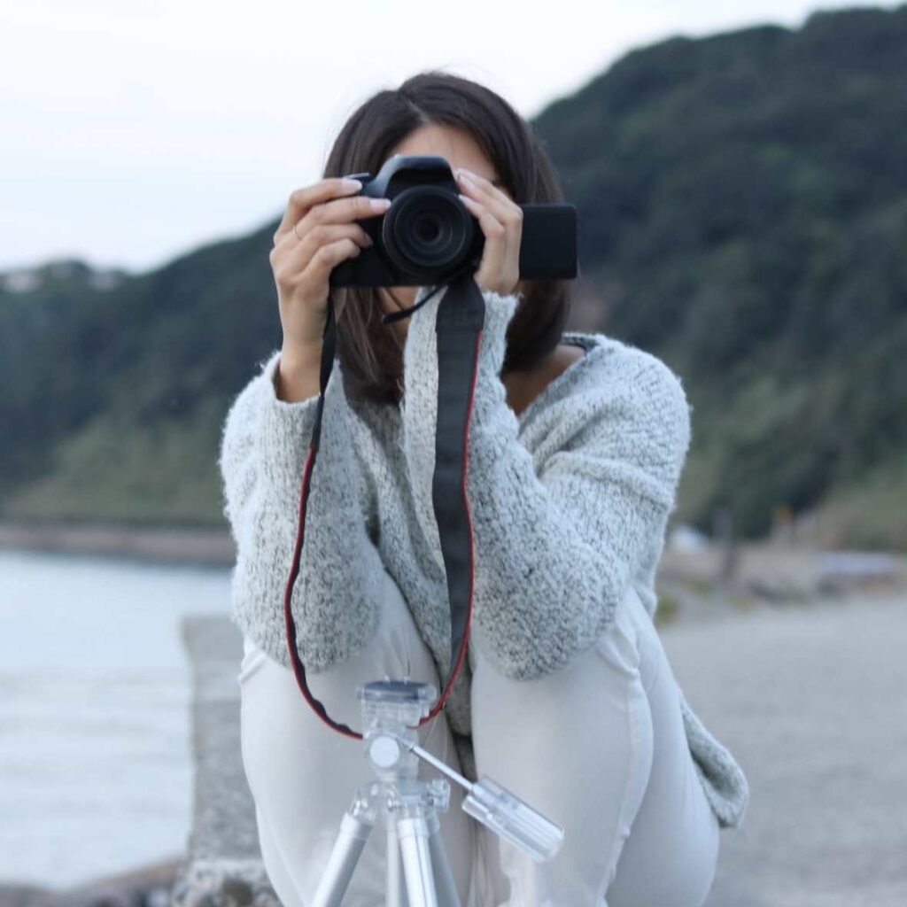 海辺でカメラを向ける女性